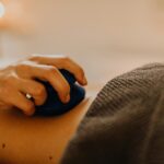 Hands applying relaxing massage therapy with hot stones in a calming spa environment.