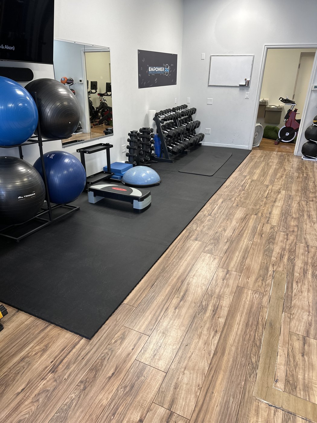 The rehab gym at Orion Physical Therapy in Springville, UT with squat rack, dumbbells and open turf space